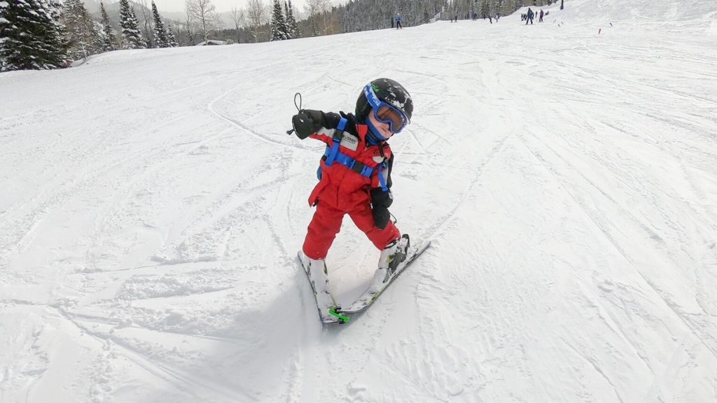 Toddler learning how to turn skiing