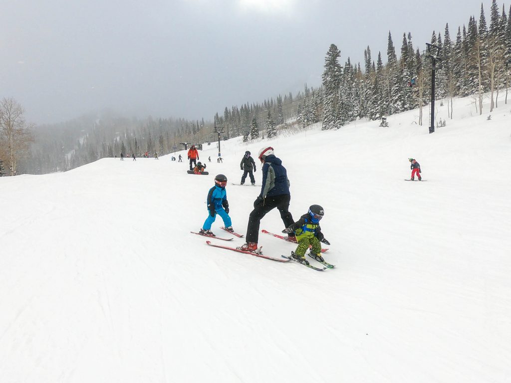 Mom skiing with little boys