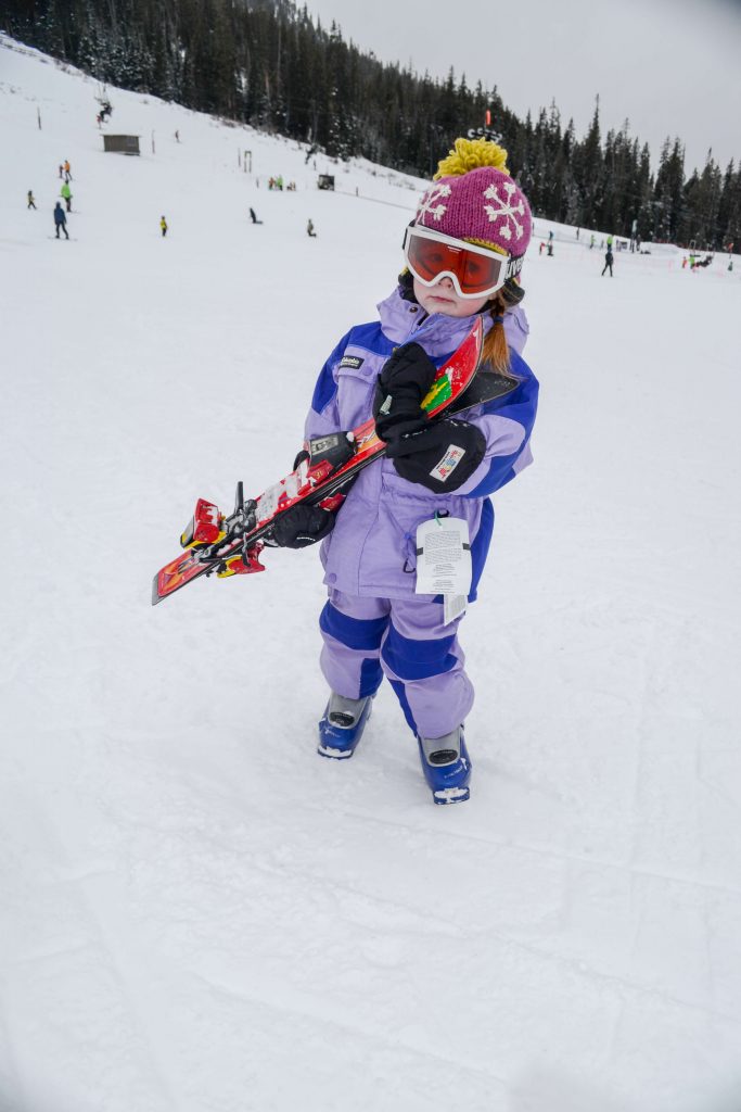 toddler carrying skis