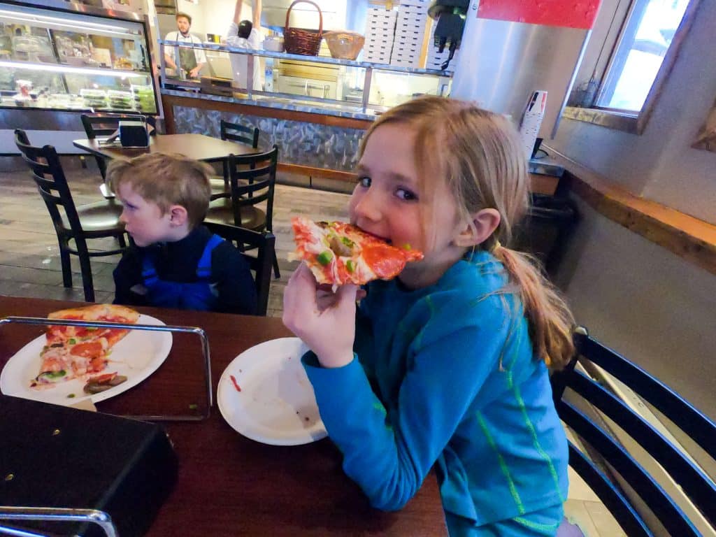 Girl eating pizza skiing