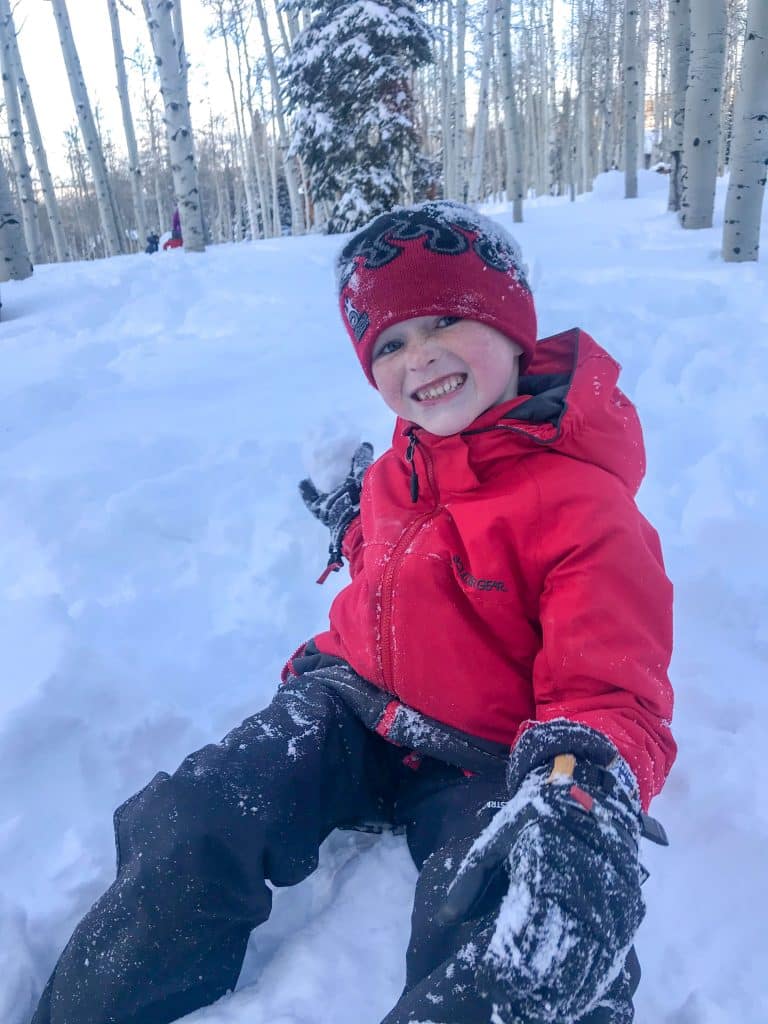 Boy playing in the snow during the ski resort childcare