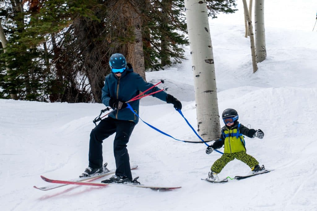 dad and boy skiing with ski harness