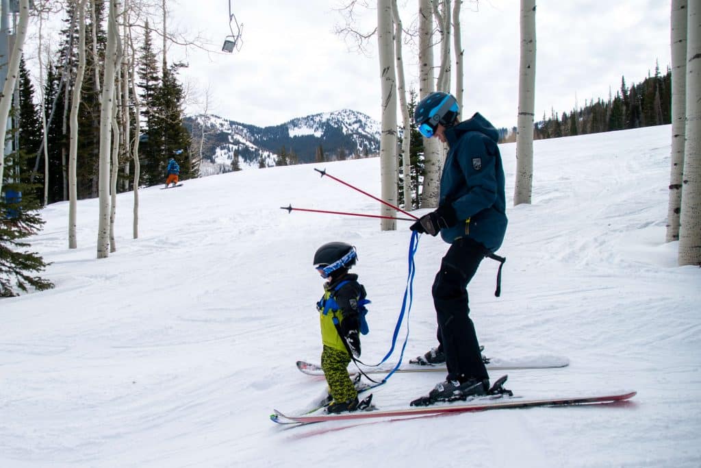 toddler skiing with a ski harness