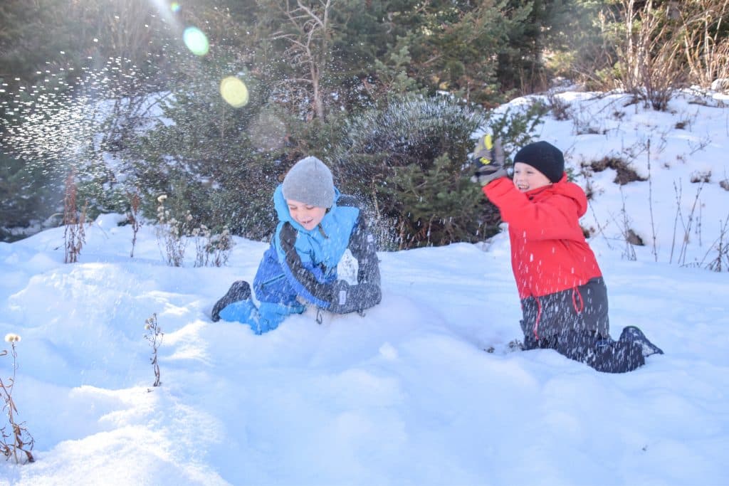 kids playing in the snow with gloves at resorts that offer childcare