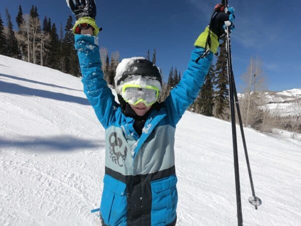 boy skiing covered in snow