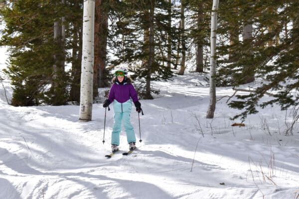 girl skiing the trees