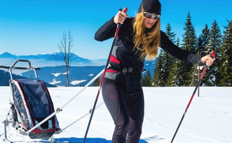 parent skiing with a ski trailer