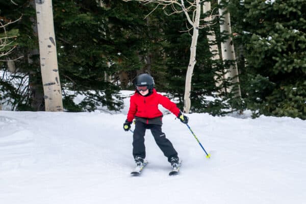 boy skiing through the trees