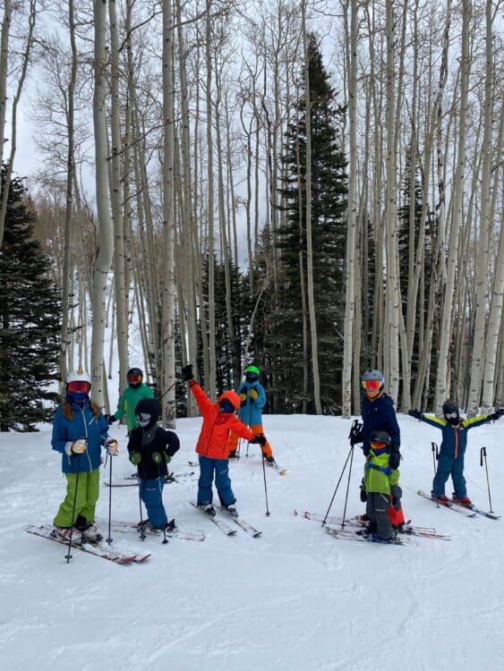 Family having fun skiing next to trees