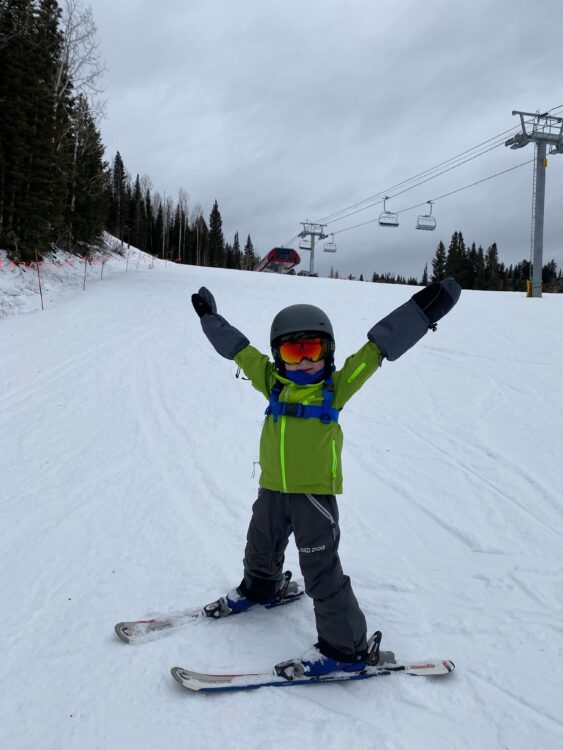 Boy having fun skiing in the snow shred dog