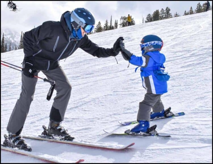 Father and son high five skiing