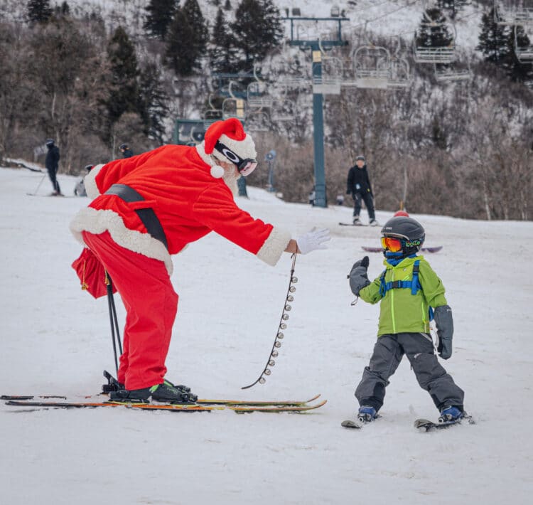 little boy skiing with santa