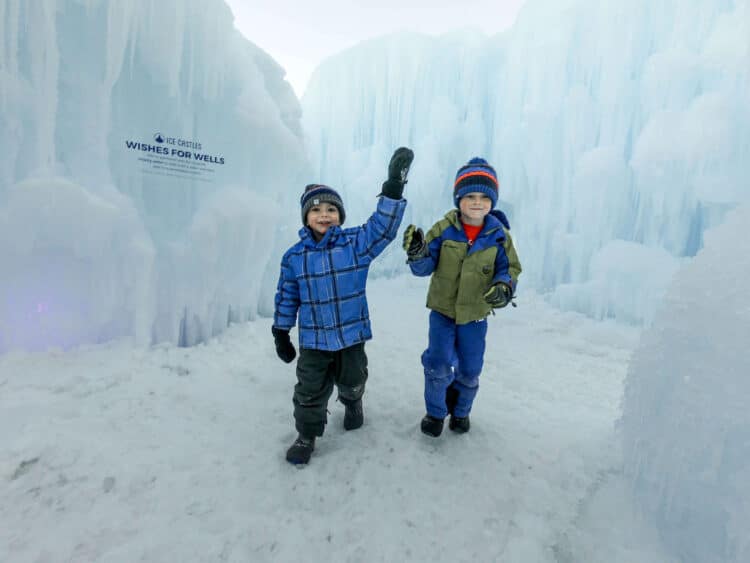 boys playin in ice castles with snow clothes and winter hats