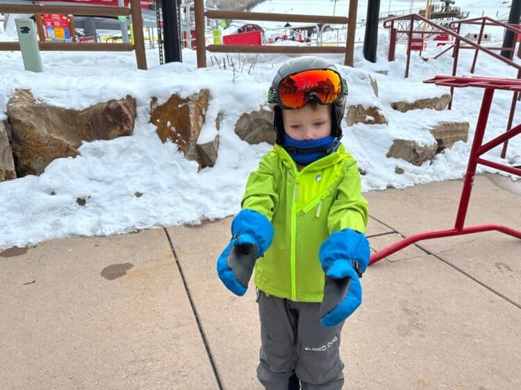 little kid carrying skis