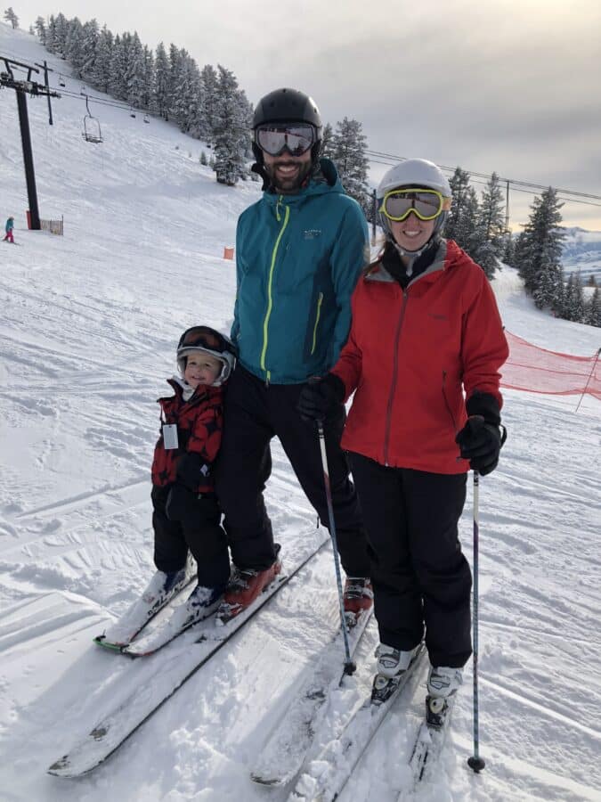 Two adults and one child skiing